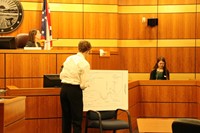 boy writing on poster diagram in court room