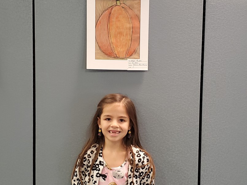girl standing by pumpkin picture