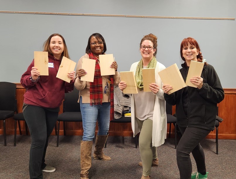 4 ladies standing holding broken boards