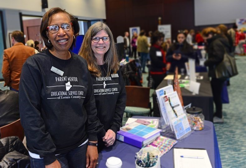 2 ladies standing by a table
