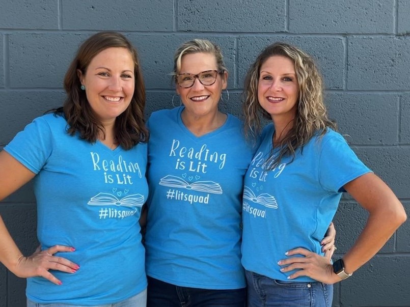 3 ladies wearing the same shirts that read Reading is Lit