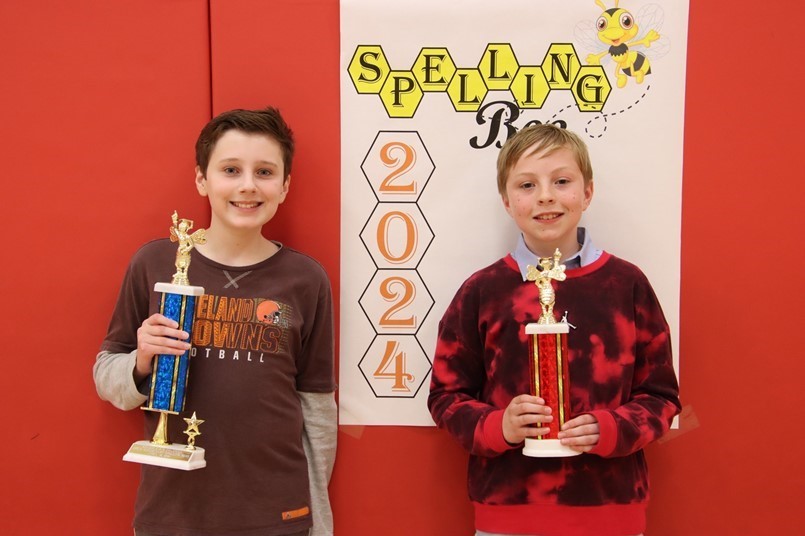 2 boys holding trophies for spelling bee 2024